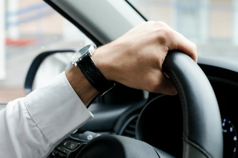 a man holding a steering wheel while driving