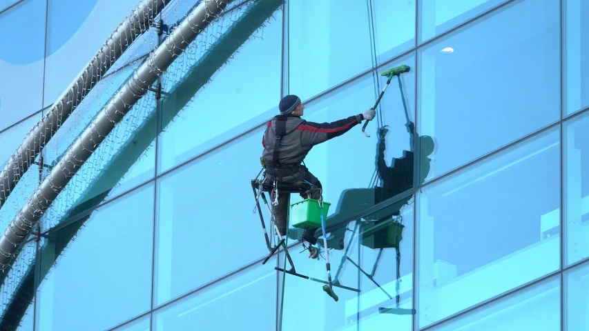 a man on a high wire rope climbing a building