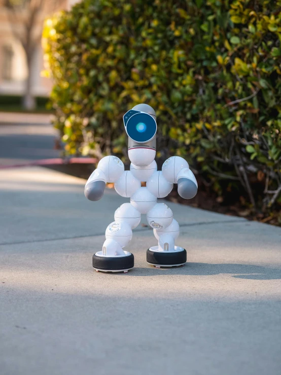 small robot model standing on top of cement