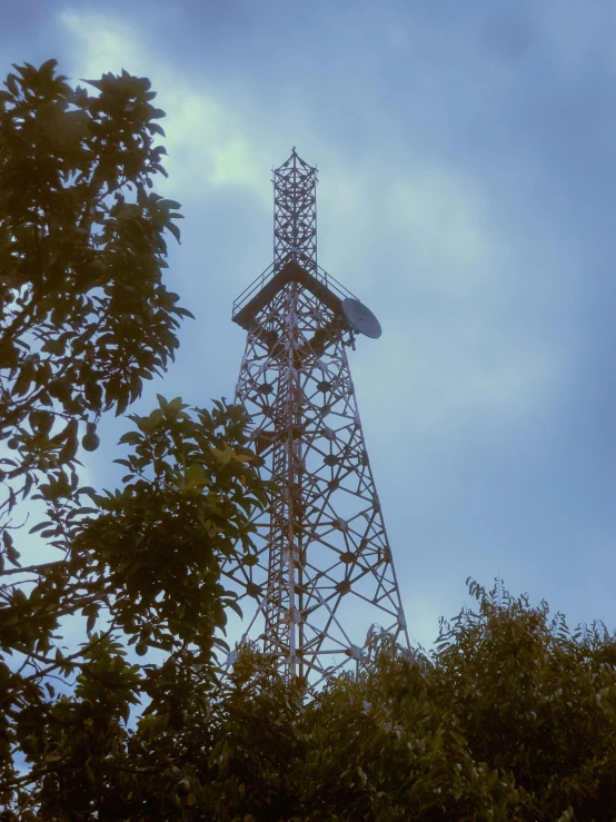 an antenna tower in the distance surrounded by trees