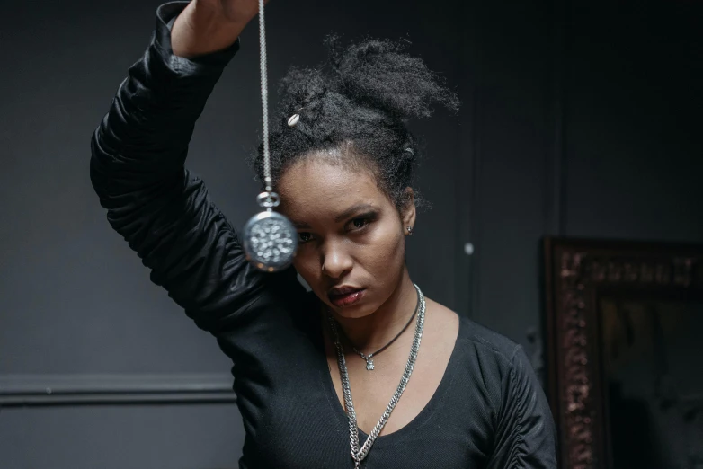 a woman in a black dress holding onto some jewelry