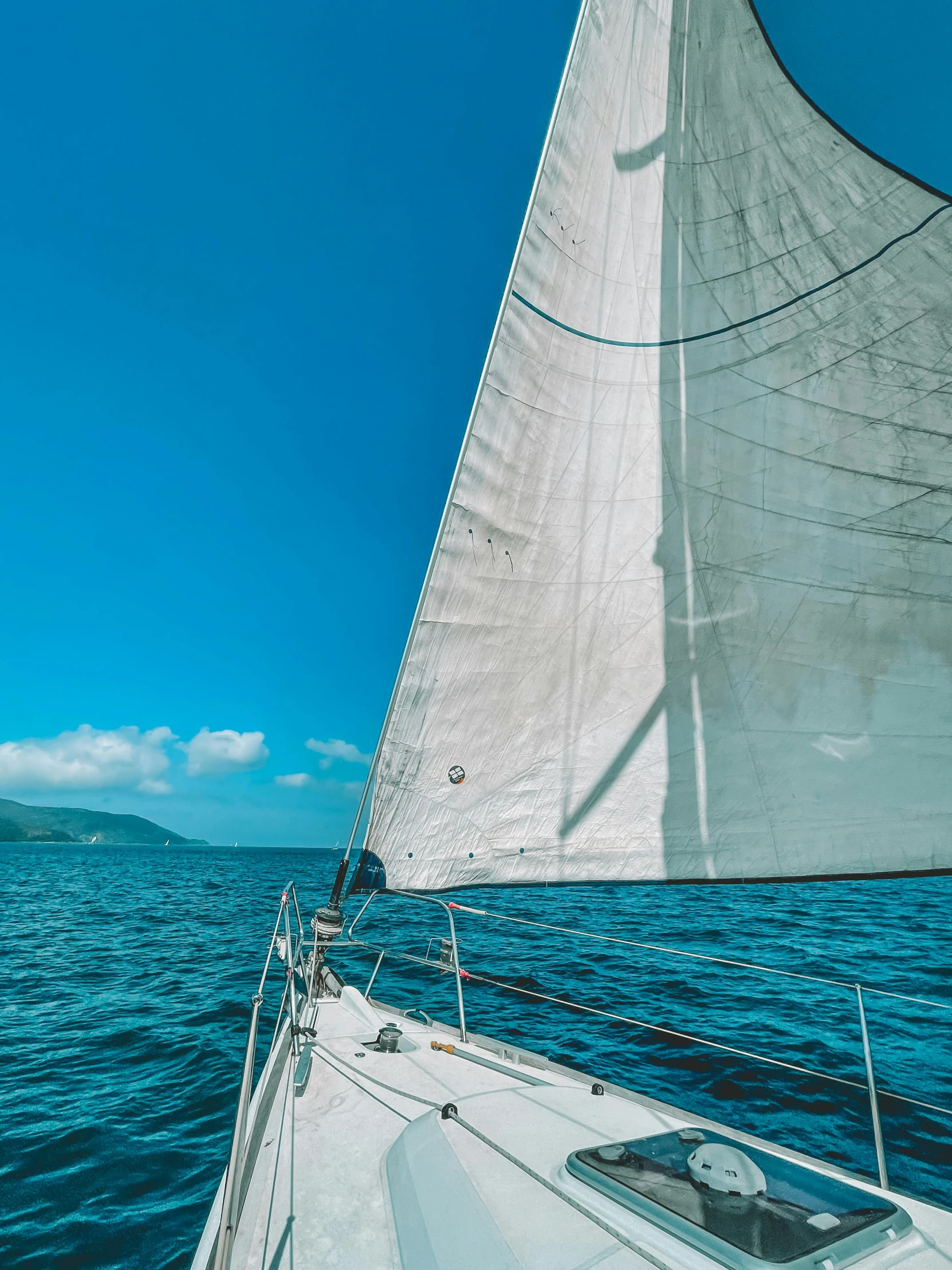 a white sailboat sailing through the water