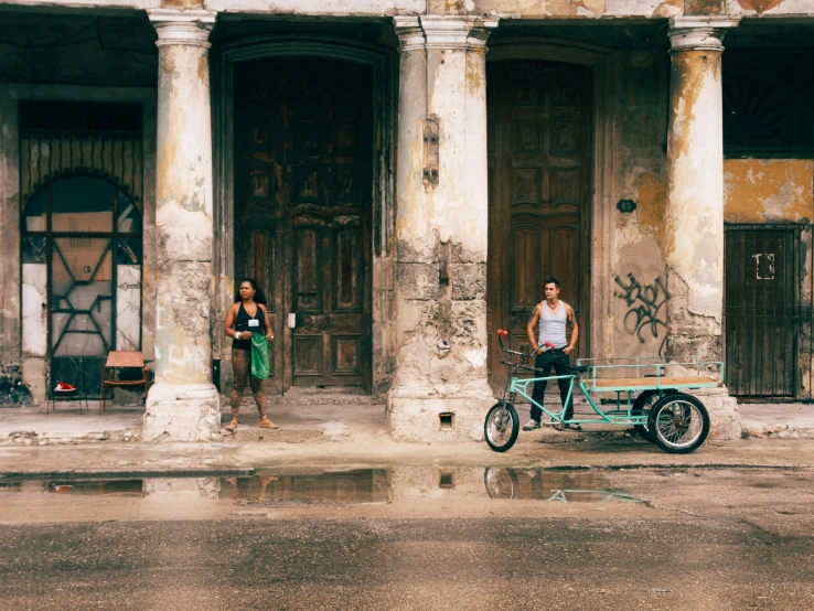 two women with a vintage motorcycle next to them