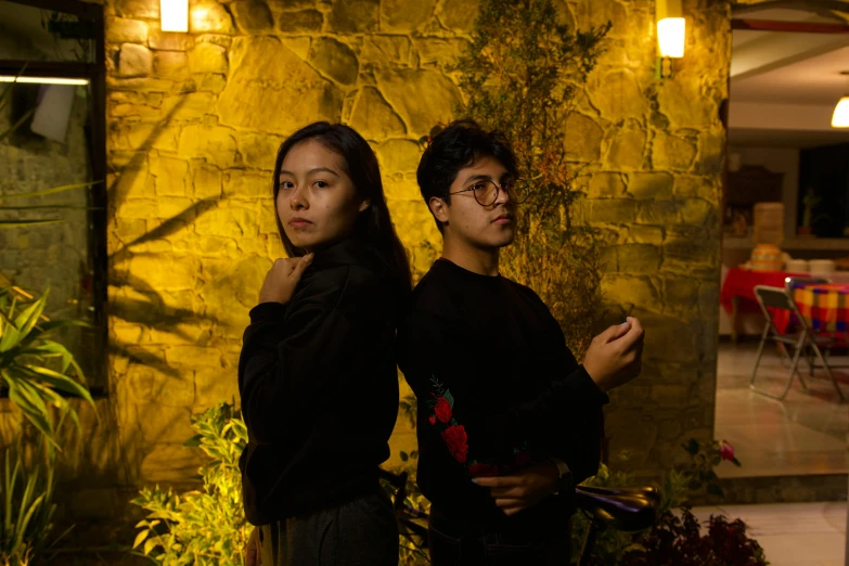 a young man and woman are standing outside