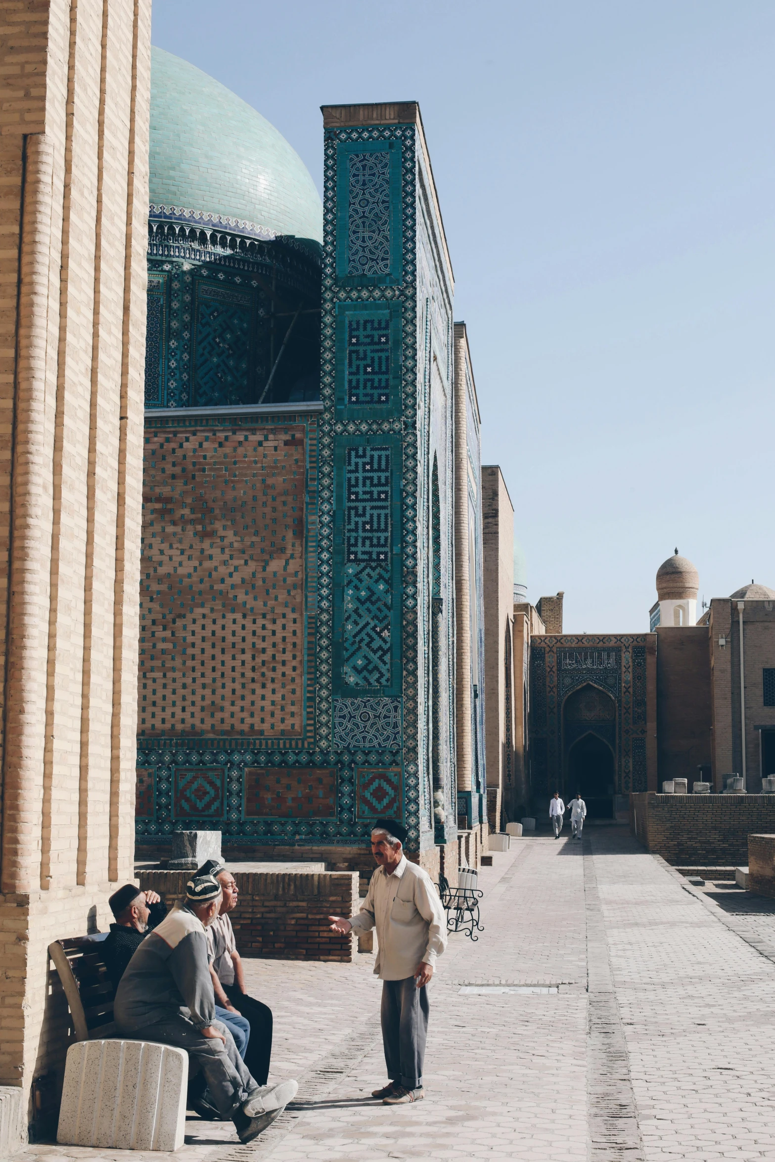 several men are sitting on benches in front of a building