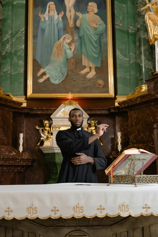 a priest is standing near a statue of the virgin mary