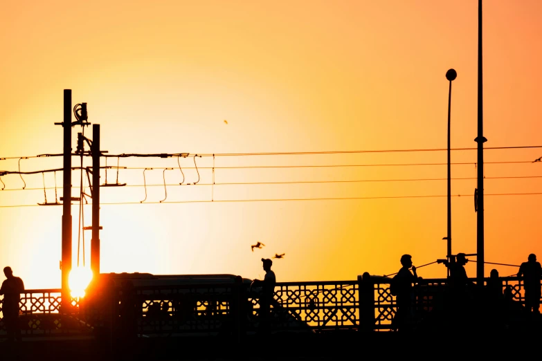 the sun is setting over some power poles and power lines