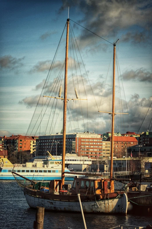 two ships are docked in the water by some buildings