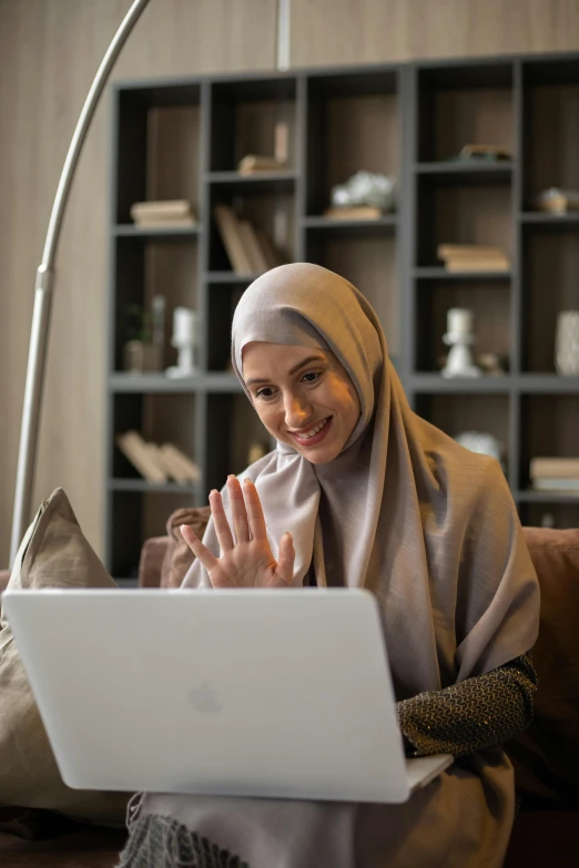 a woman in hijab sitting at a computer