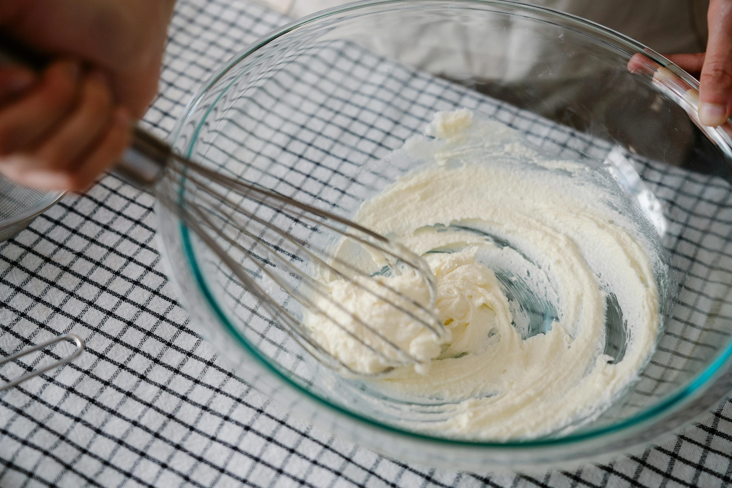 someone mixing the cream into the whipped sugar mixture