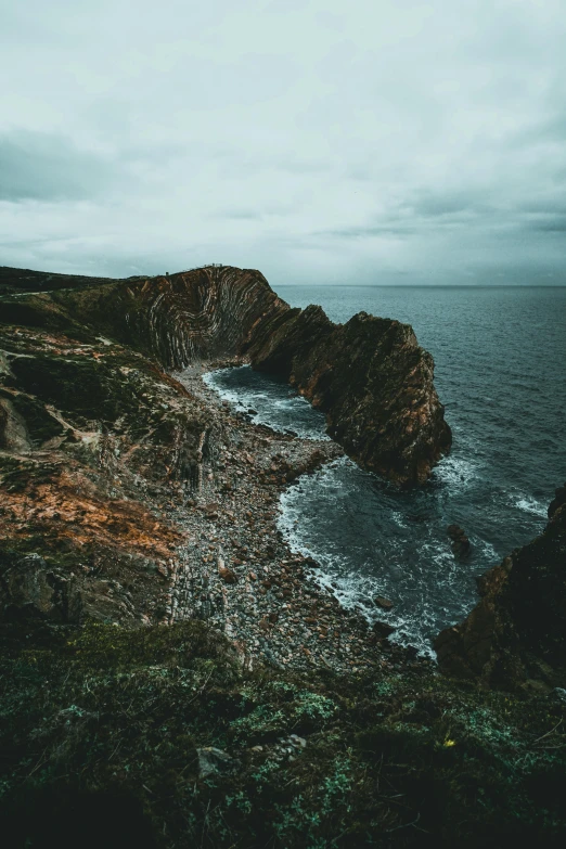 the ocean and rock are beside the shore