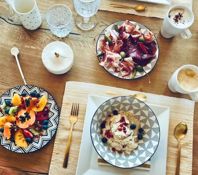 two plates with small food items and cups of water on a table