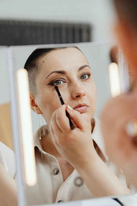 a young woman is seen in the mirror while holding a lipstick brush