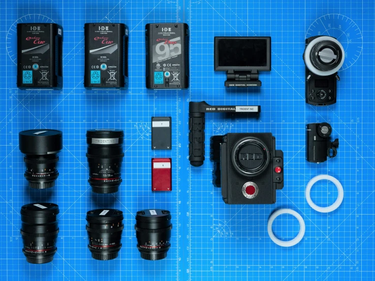 some various types of cameras and parts on blue