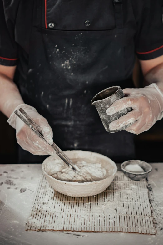 a chef holding onto two cups in front of him