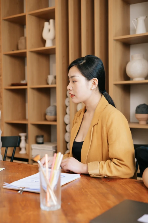 a woman sitting at a desk writing on paper