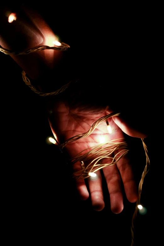 a person holding a string lit with light strings