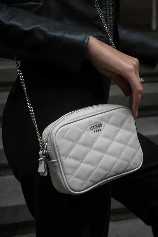 woman in a black dress holding a small white purse