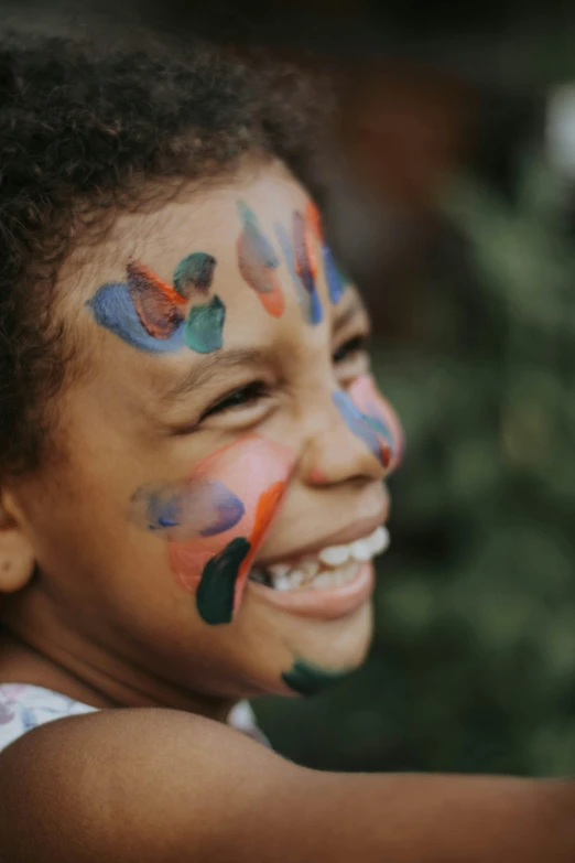 a young child with face paint is smiling