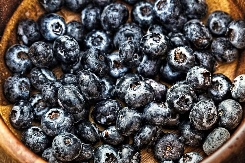 a bowl filled with blueberries sitting on top of a table