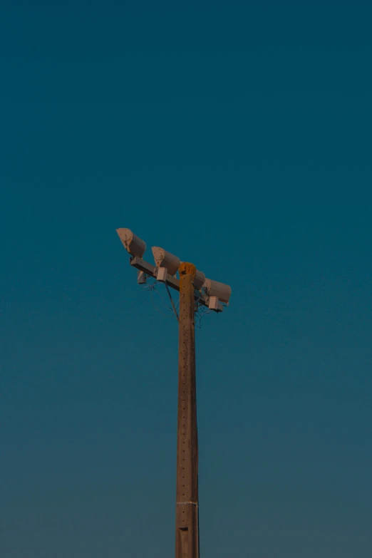 two large outdoor cameras mounted to the top of a pole