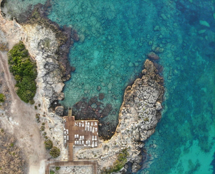 a house surrounded by rocks near water