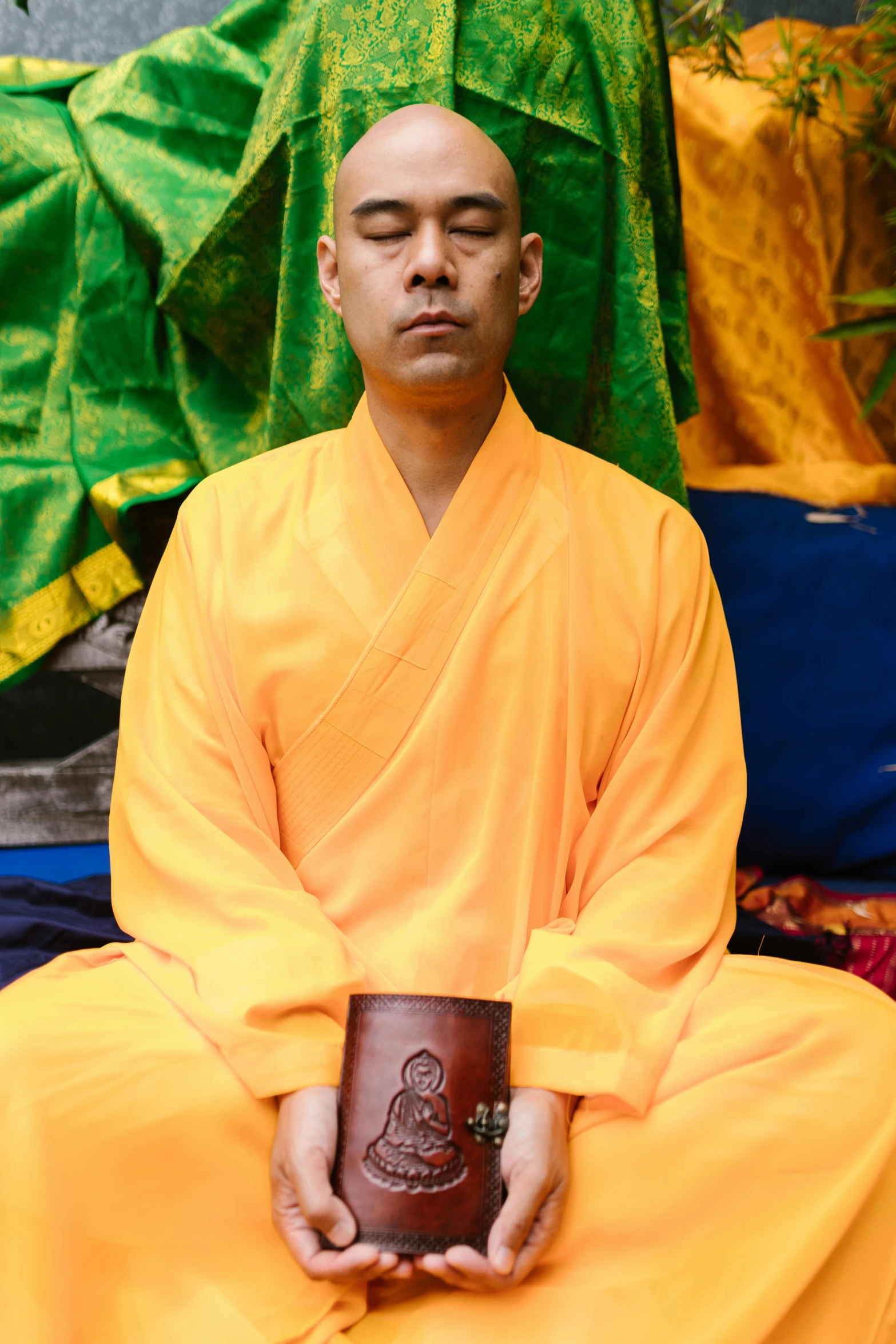 a man sitting in front of a large pile of fabric