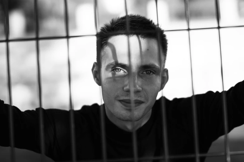 man with hand painted face behind bars in cage