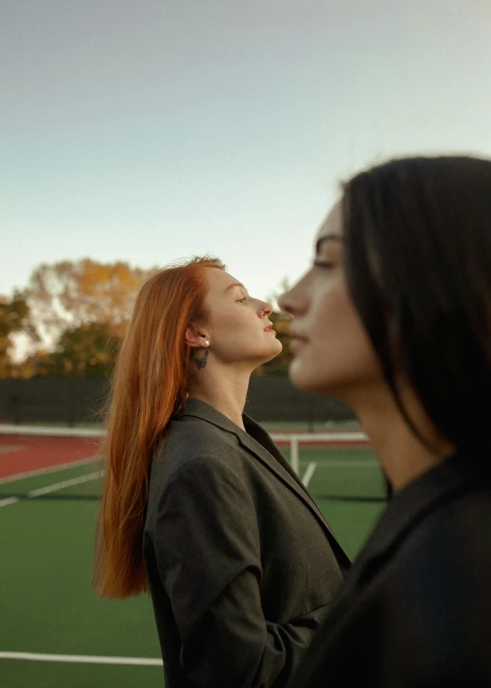 two women stand on the tennis court