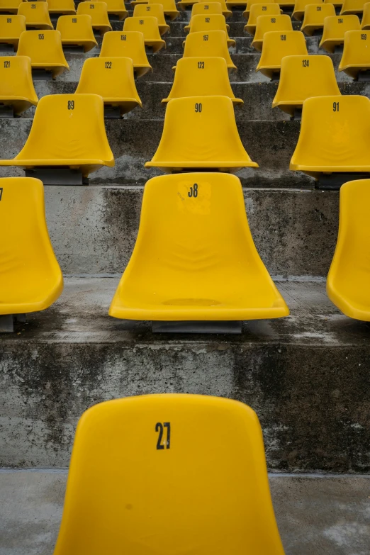 some yellow empty chairs with numbers on them