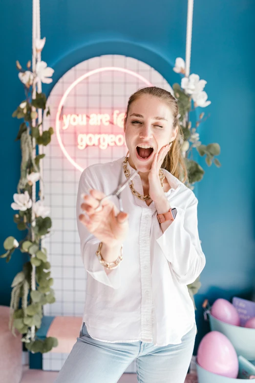 a young woman laughing and posing in front of a pink sign