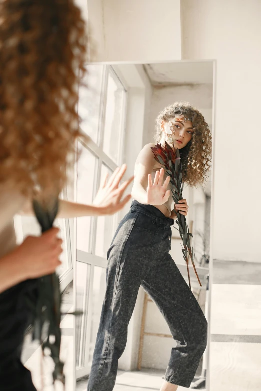 a woman holding a gun near a mirror