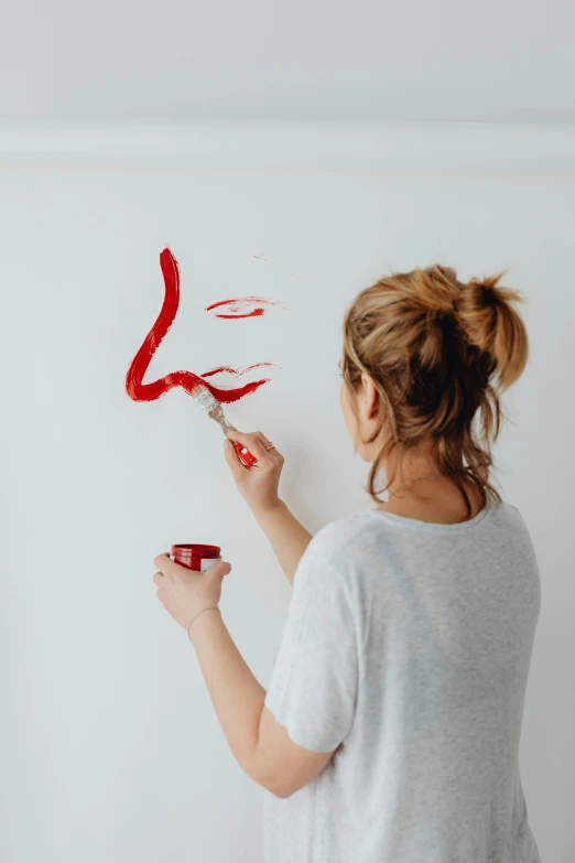 a woman is painting the numbers on a wall