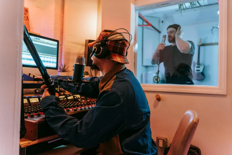 a man is sitting at a desk while recording a song