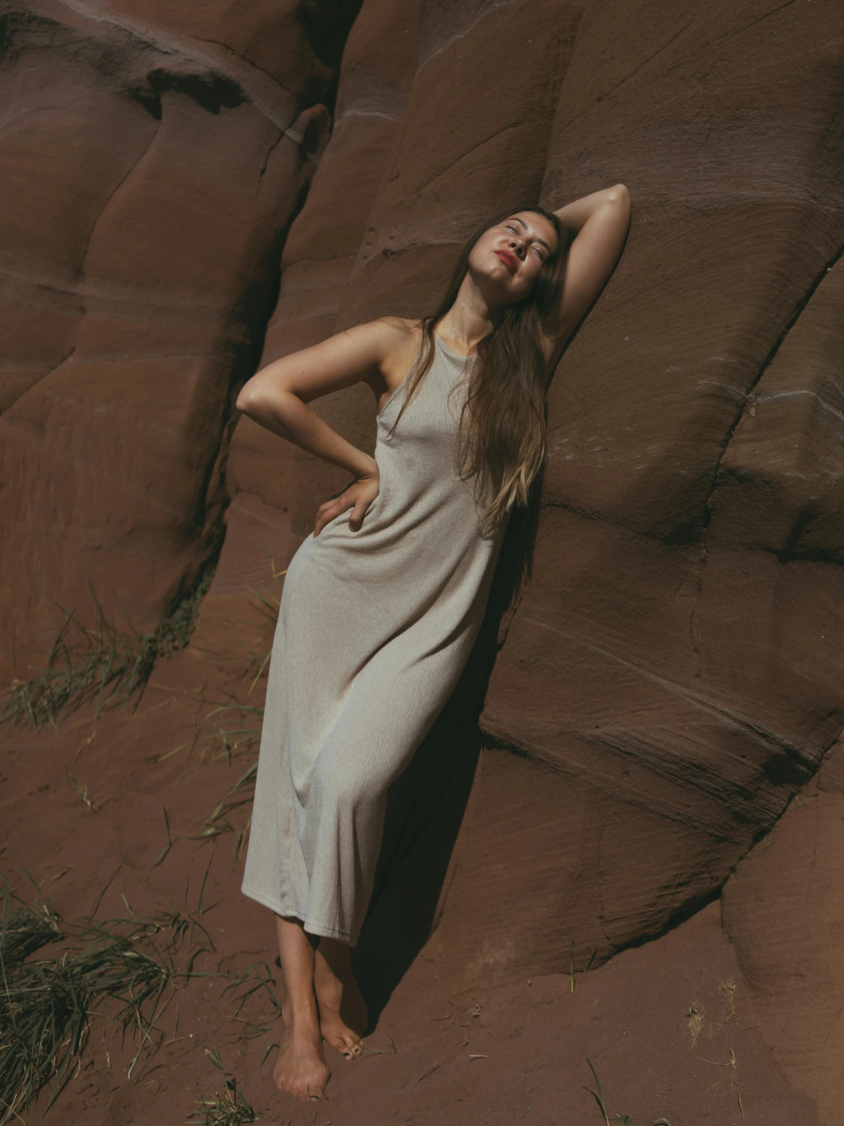 a young woman in a long dress posing on the rocks