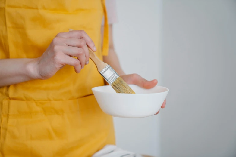 woman holding a bowl and brush with white handle