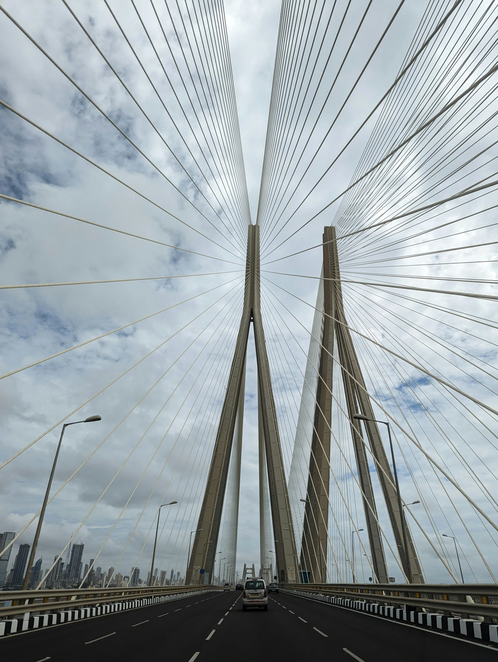 the underside view of a large bridge with many cables above