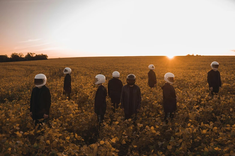 a group of people standing in a field with white hats