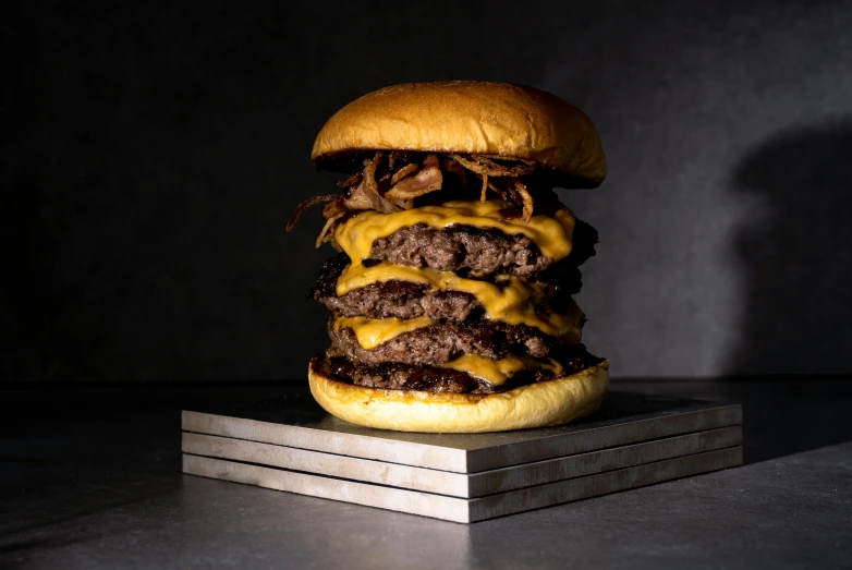 the burger has been cut in half and is being stacked on top of a couple of other slices