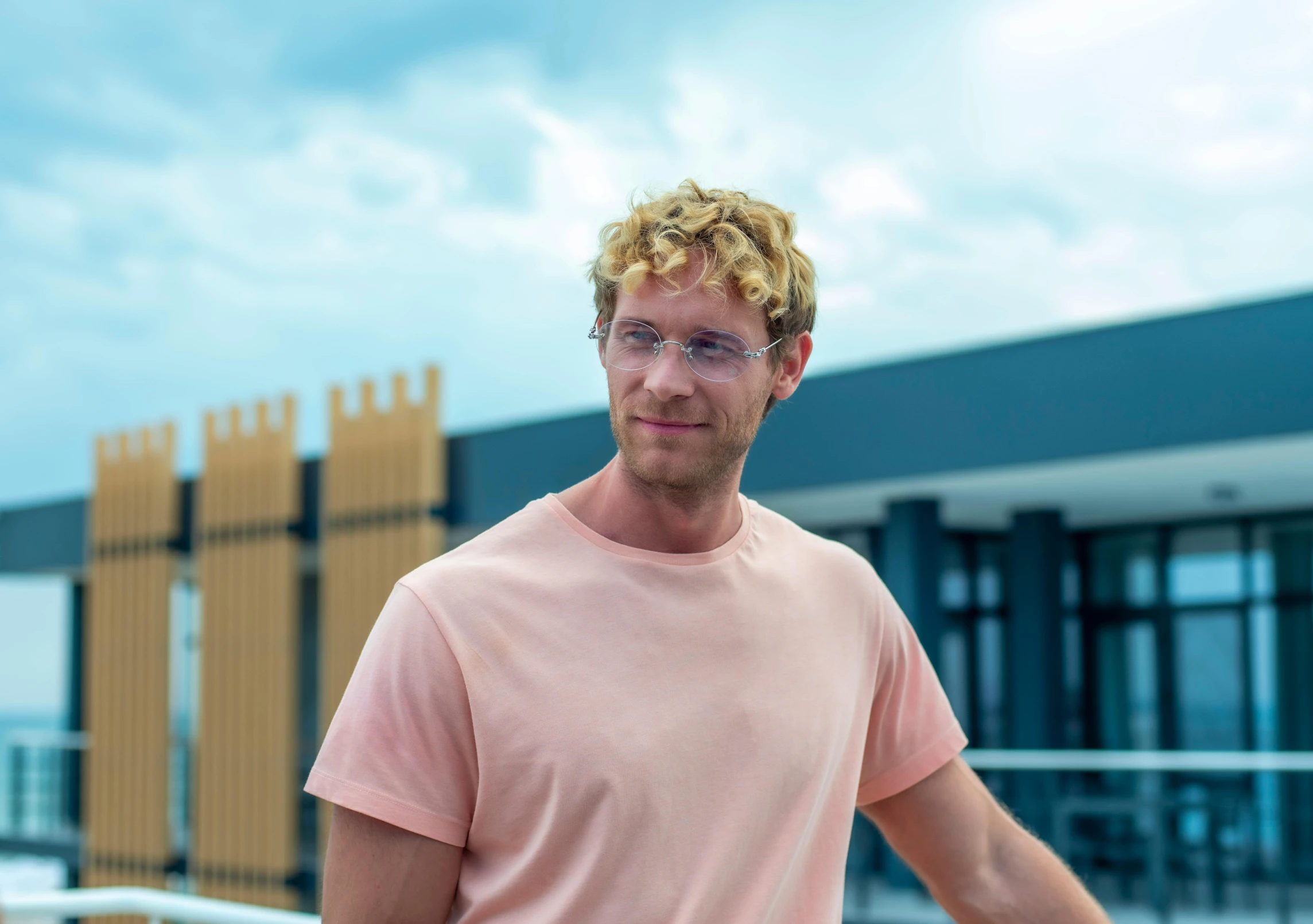 a man in a pink shirt posing for the camera