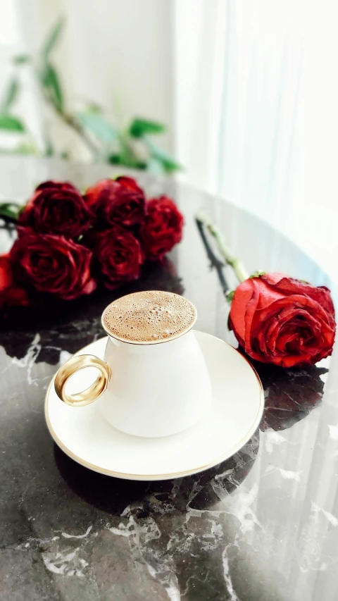 two red roses with gold wedding rings on a black table