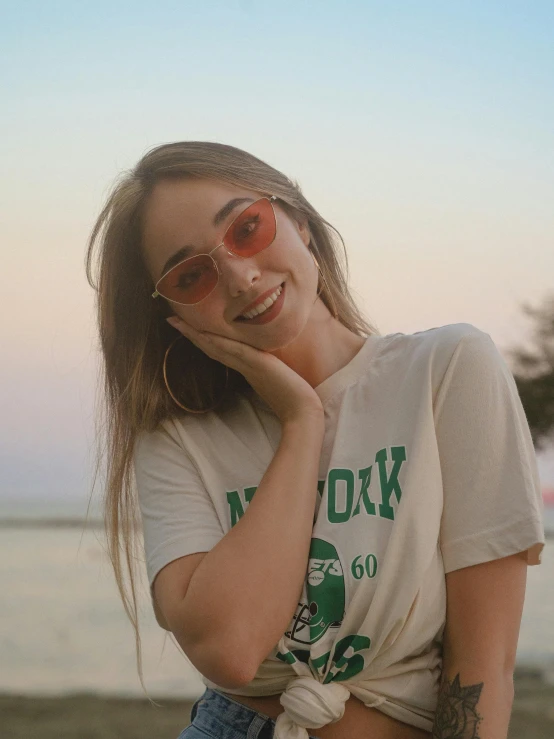 a young woman poses in her shirt on the beach