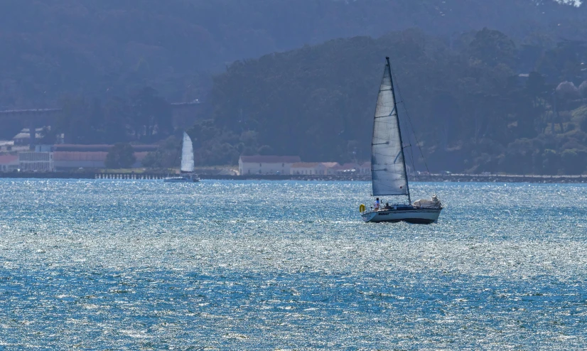 the view from the ocean shows a sailboat and small lighthouses