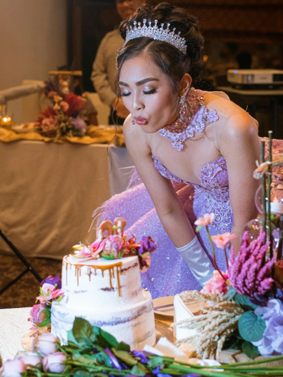 a bride leaning down and  into a wedding cake