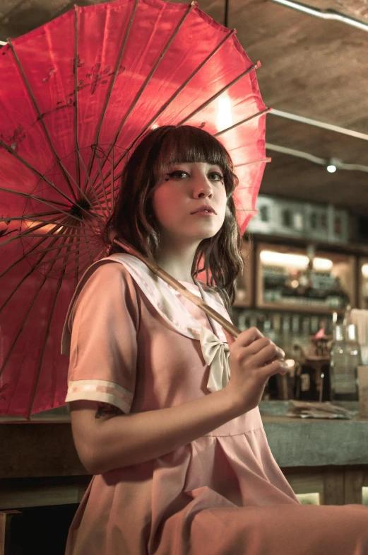 girl holding red umbrella in front of a bar