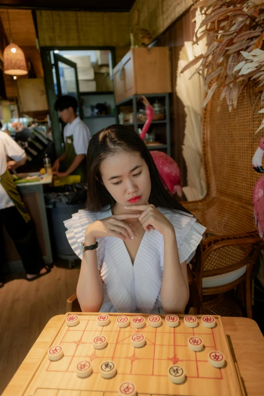 a woman at a table with a board game