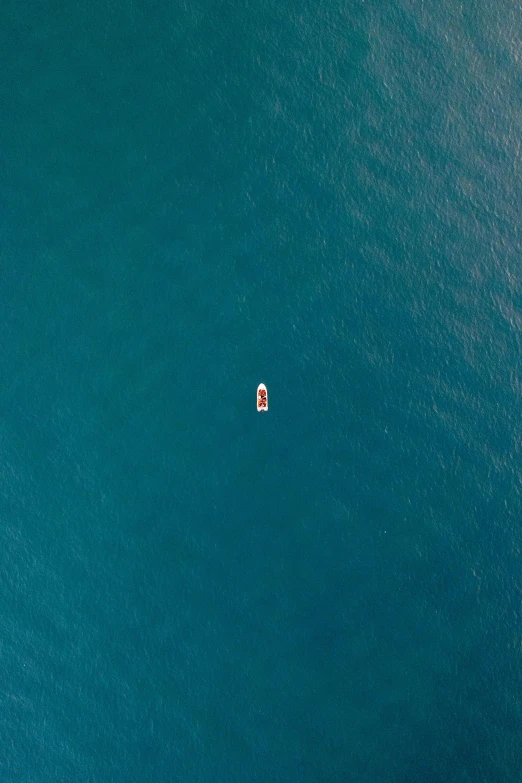 an orange boat floating on top of a body of water