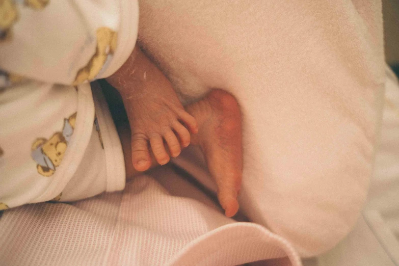 an infant's feet and foot of a baby wrapped in blankets