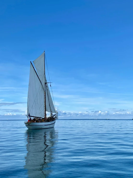 a sail boat that is in the middle of some water