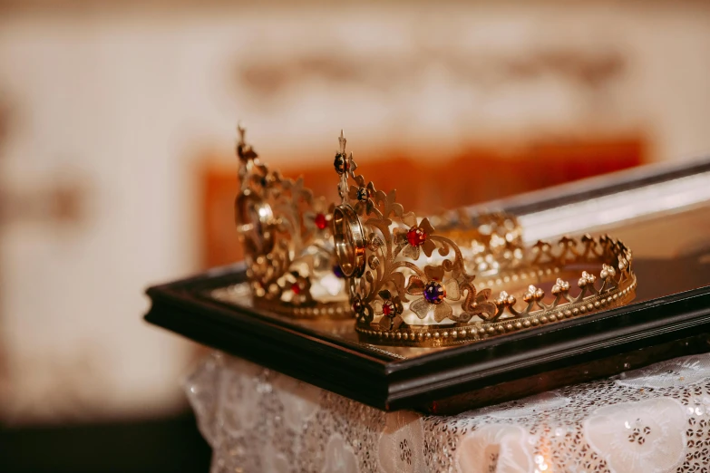 a gold crown rests on a table with lace